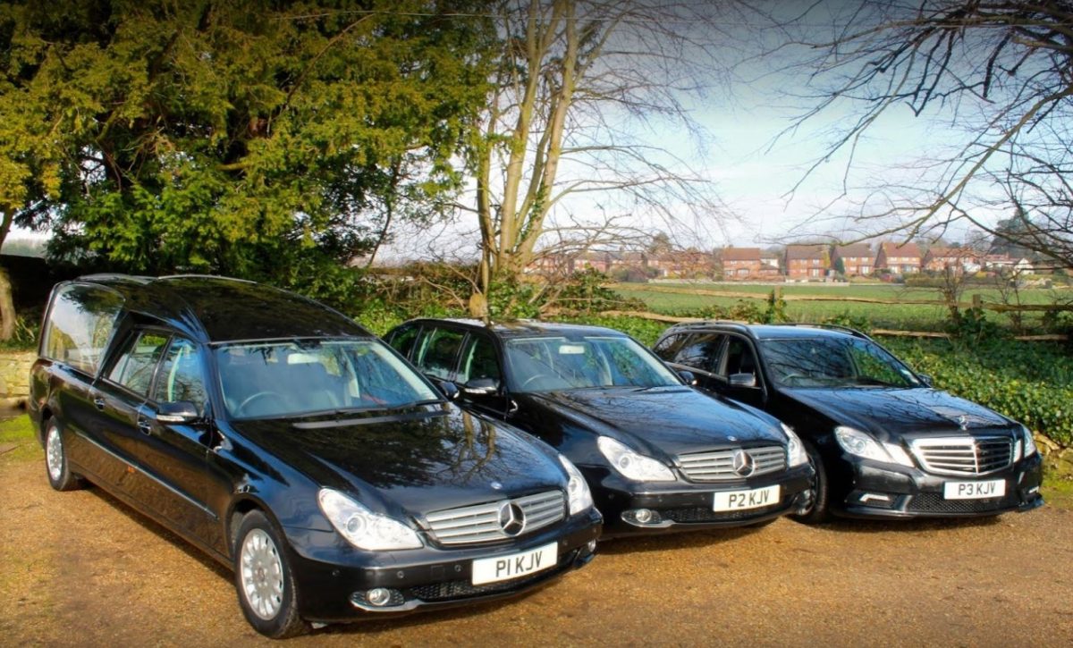 Three black Mercedes funeral vehicles; one hearse, one limousine and one estate car