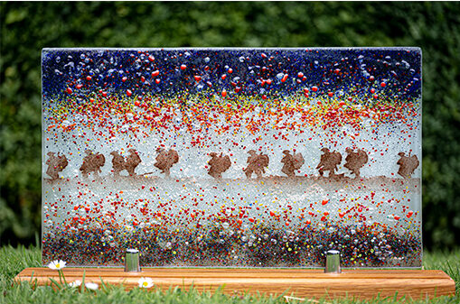 Lest we forget artwork showing soldiers walking in a line through a poppy field