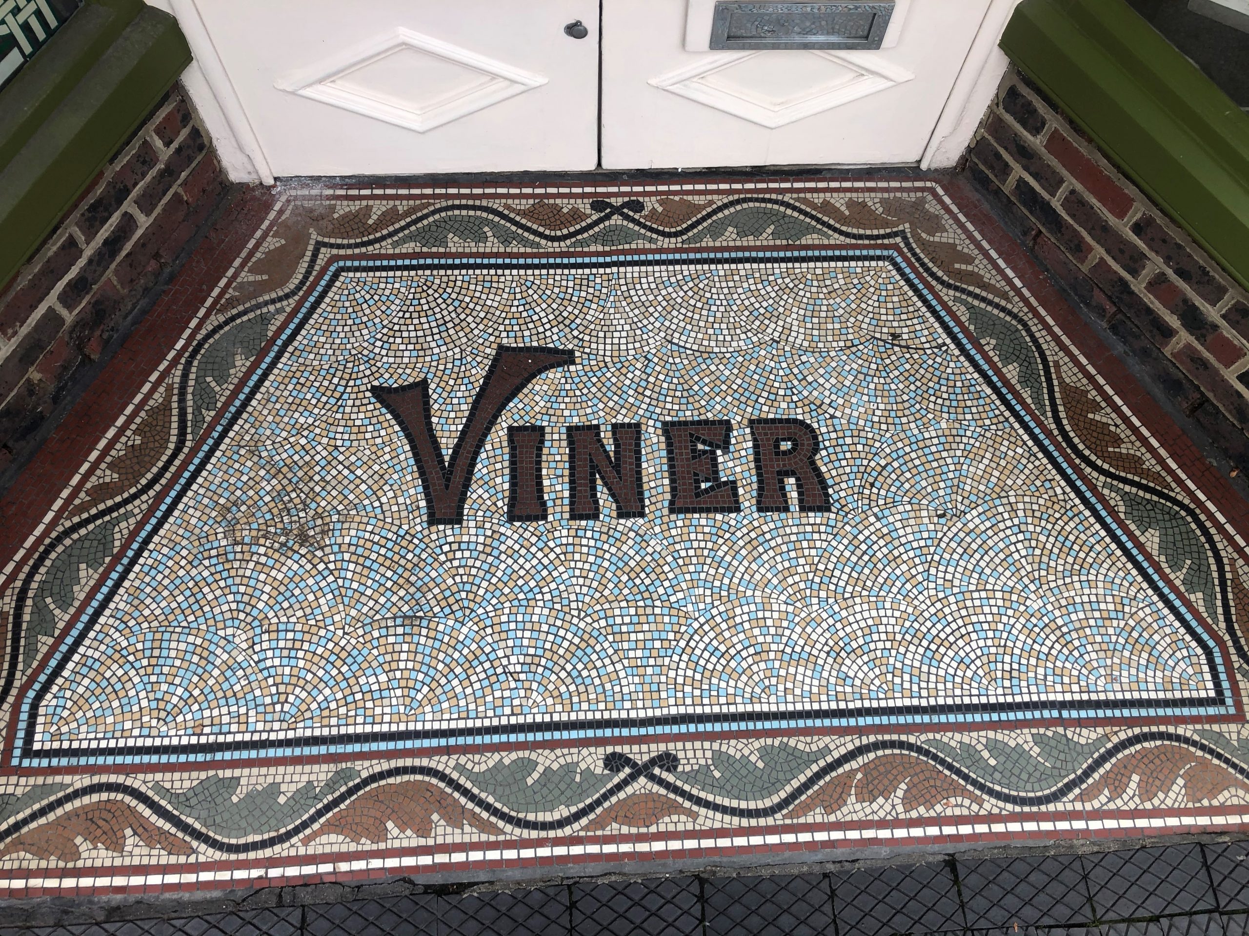 Mosaic tiles on the floor spelling out 'Viner'