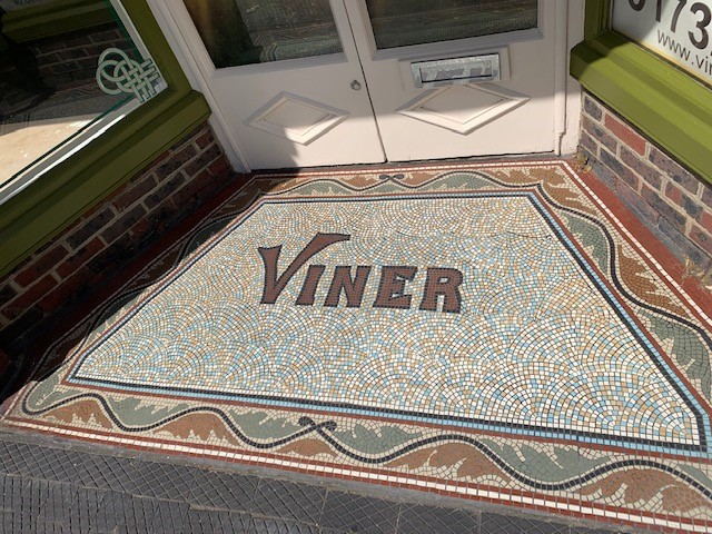 Mosaic tiles on the floor spelling out 'Viner'